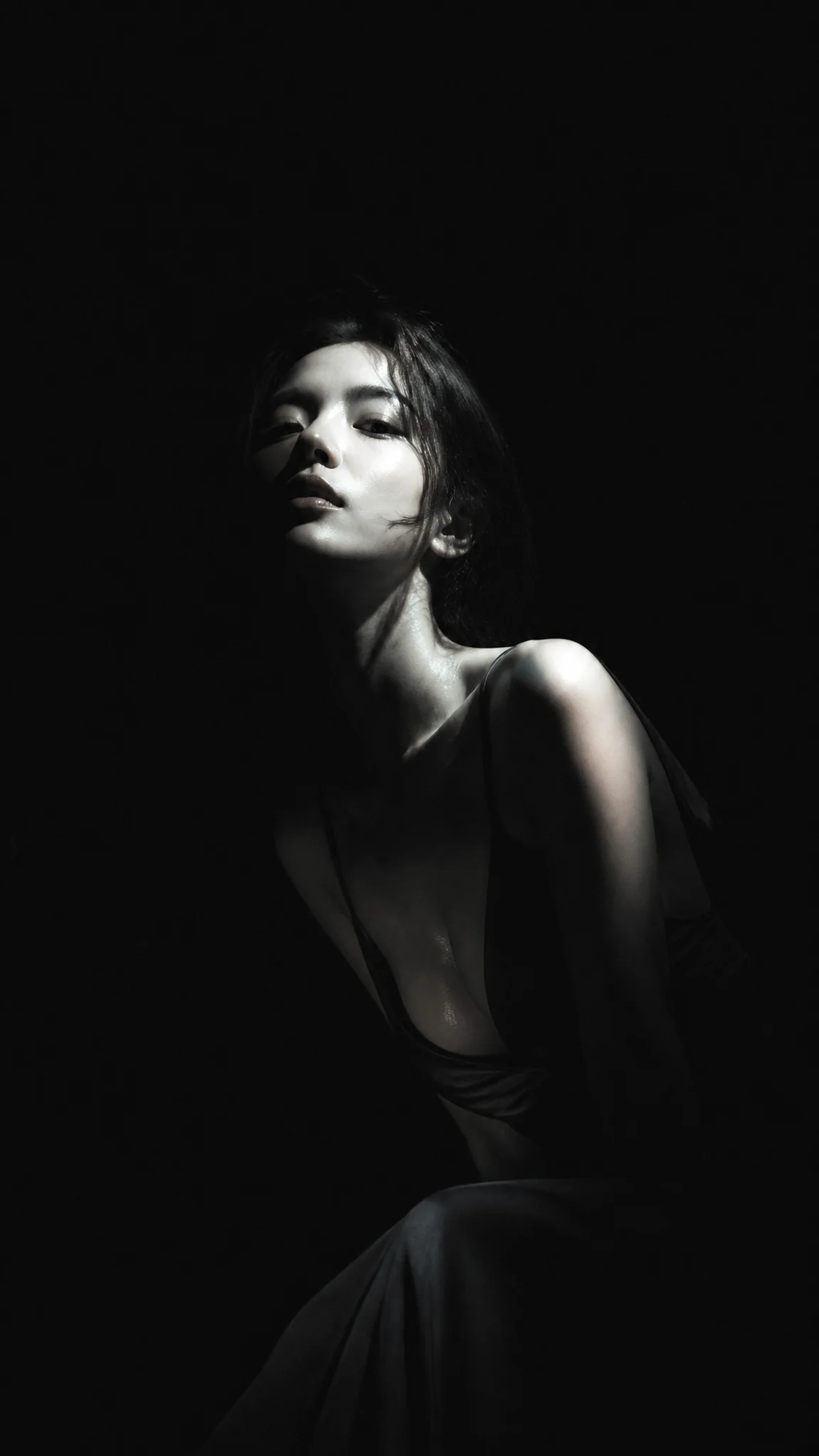 暗黑极简冷光半写实插画，主体为身穿深色低领长裙的漂亮韩国女明星，眼神冷峻，面容俊俏，纯黑背景，大面积黑场吞没画面，...